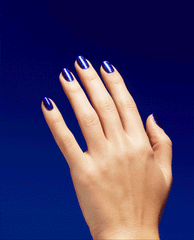 Hand with medium-length nails painted in Scorpio Seduction, a shimmering deep blue OPI nail polish nail lacquer, slowly tilting to catch the light against a rich cobalt blue background.