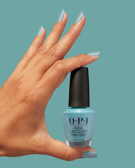 OPI Reality Check Ya Out Nail Lacquer bottle held between manicured fingers, showcasing shimmery aqua‑green nail polish on nails against a matching teal backdrop—15 mL/0.5 fl oz—a fresh pick for spring nail colors from OPI.