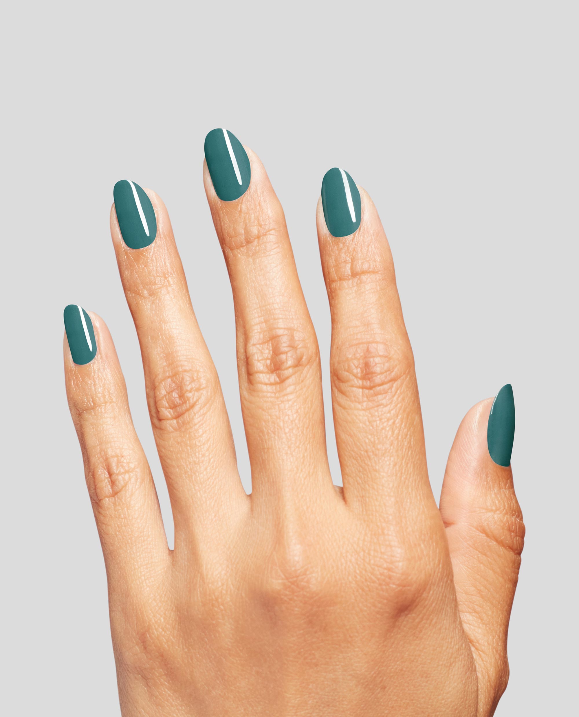 Hand with medium skin tone displaying neatly manicured nails painted in Baby Tee-l, a rich teal OPI nail polish nail lacquer shade, against a light gray background to showcase the glossy color and smooth coverage.