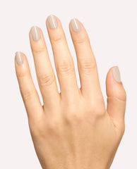 Hand modeling glossy taupe-beige OPI Berlin There, Doin’ That nail lacquer on short rounded nails, a neutral shade for fall nail colors against a clean light background.