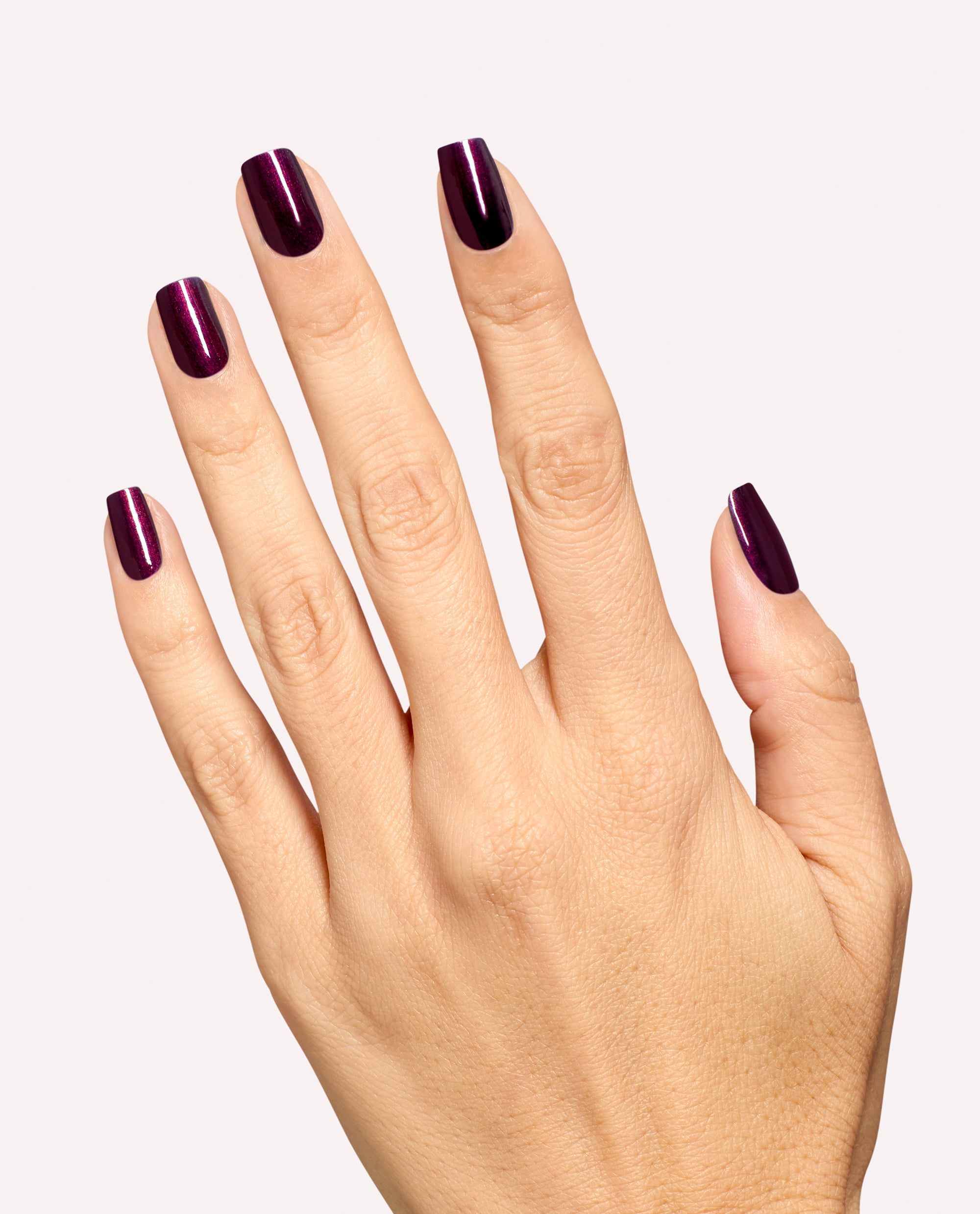 Hand modeling OPI Every Month is Oktoberfest gel nail polish, a glossy deep plum-burgundy shimmer shade on short square nails against a clean white background, ideal for fall nail colors.
