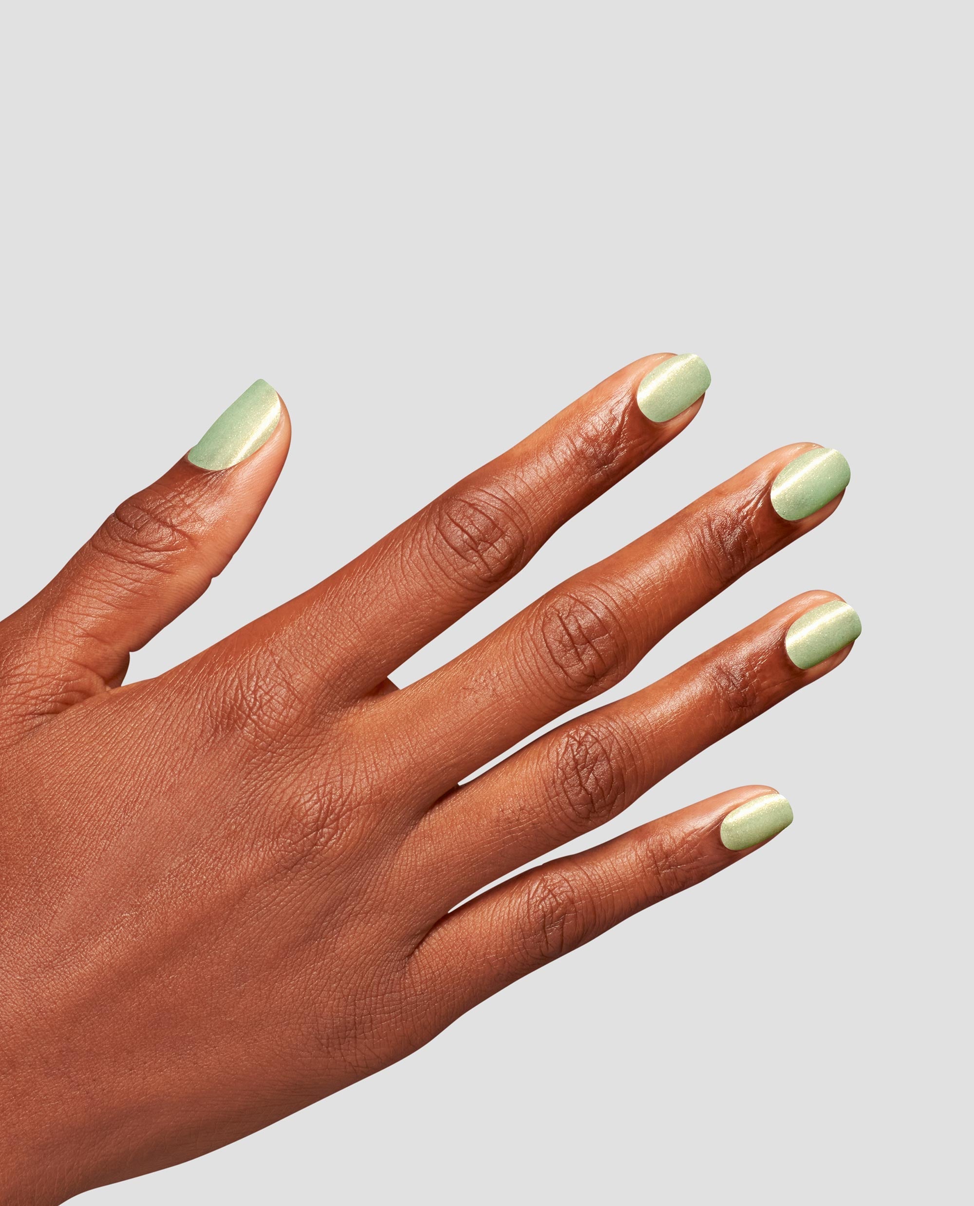 Mint-green manicure showcasing OPI AppointMINT Confirmed nail lacquer, a soft shimmery green nail polish, on neatly filed short nails, hand angled against a clean light gray background, perfect for spring nail colors.