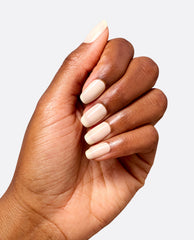 Hand displays glossy soft ivory nails wearing OPI Throw Me a Wink nail lacquer, a subtle neutral option for fall nail colors on a clean white background.