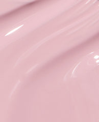 Glossy pale pink OPI nail polish, You’ve Got that Glas-glow, flowing in smooth, wavy brushstrokes that highlight its glass-like shine and creamy nail lacquer texture on a clean studio backdrop.