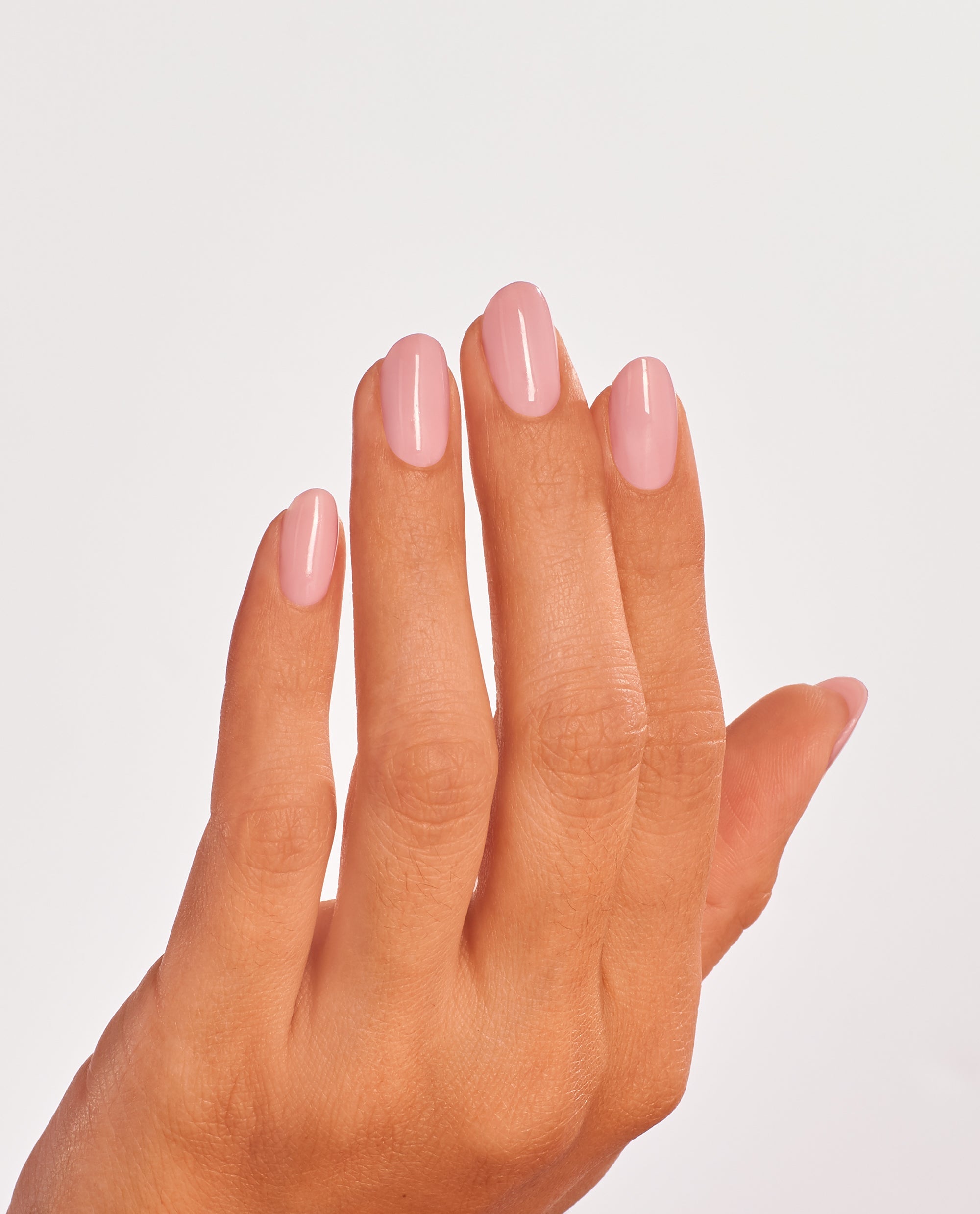 Hand shows neatly manicured nails painted in You’ve Got that Glas-glow, a sheer glossy pink OPI nail polish nail lacquer, against a clean white background, highlighting the smooth, even coverage and natural salon-quality finish.